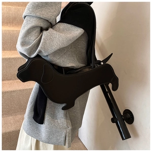 Creative black dachshund dog shaped handbag shown in a stylish streetwear fashion setting