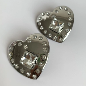 Detailed view of heart-shaped silver earrings with square center crystal and small diamonds
