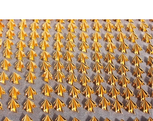 Detailed view of golden irregular pleated metal earrings on a soft grey foam display