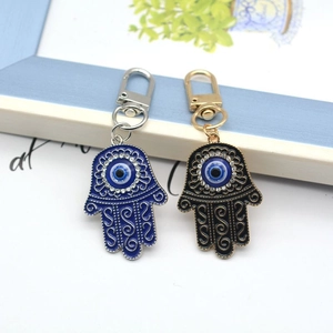 Detail of Hamsa Hand keychains with blue and black enamel and Evil Eye crystal inlay