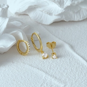 Macro detail of S925 sterling silver gold earrings set with sparkling zircon stones