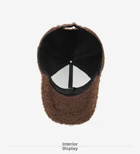 Detailed inside view of brown teddy fleece baseball cap with black lining and metal buckle