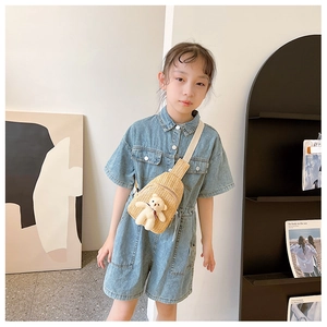 Detail of yellow hand-woven straw crossbody chest bag with cute plush bear for kids
