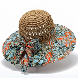 Detail of bohemian sun hat with straw crown, cashew flower brim, and elegant bow decoration
