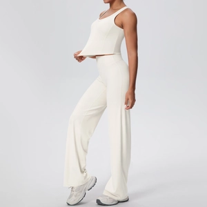 Dettaglio del set beige con pantaloni yoga a vita alta larghi e canotta corta sportiva