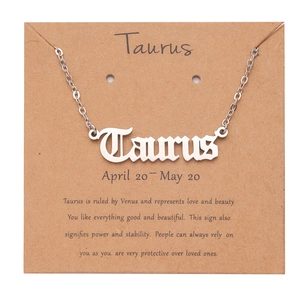 Detail view of silver Taurus zodiac pendant with gothic lettering and personality card