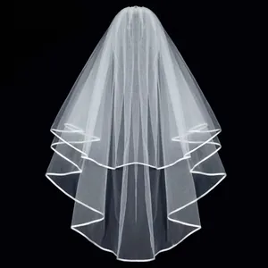 Elegant white two-tier bridal veil with satin ribbon edge trim against black background