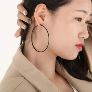 Close-up of large minimalist black hoop earrings worn for a stylish street look