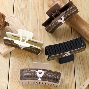 Flat lay of colorful PU leather claw clips featuring a western cow skull and geometric pattern
