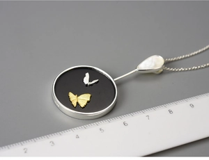 Macro shot of S925 sterling silver butterfly pendant with size measurement ruler