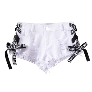 Dettaglio degli shorts in denim bianco con nastri laterali stringati e orlo con frange