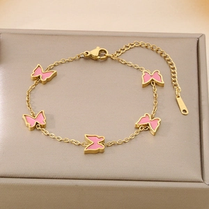 Detail of gold butterfly bracelet with pink enamel charms on luxury jewelry display box