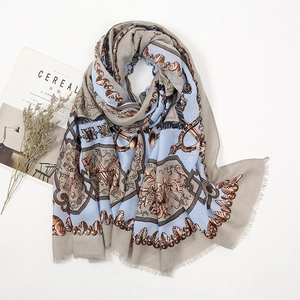 Detailed flat lay of a bohemian paisley scarf with artistic scrolls and tassel trim