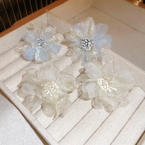 Detail of delicate organza flower earrings with pearls in a velvet jewelry box