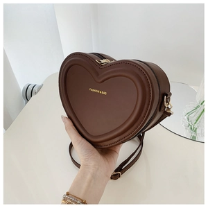 Dettaglio della borsa a tracolla in pelle a forma di cuore marrone scuro elegante