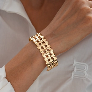 Detail of chunky gold triple-layered hollow open cuff bracelet on model wrist