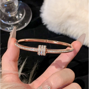 Macro di bracciale in titanio oro rosa con pavé di cristalli e dettaglio cilindrico