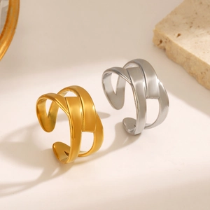 Minimalist interwoven hollow titanium steel rings in gold and silver finish on stone
