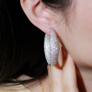 Chic silver hoop earrings with micro-pave cubic zirconia crystals on a female model