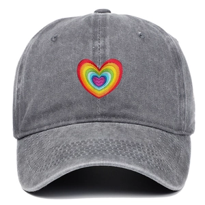 Detailed close-up of rainbow heart embroidery on dark gray washed cotton baseball cap
