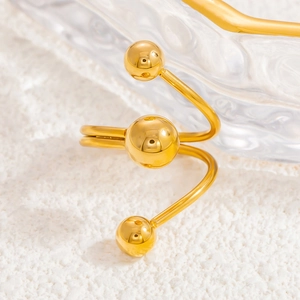 Close-up of 18k gold-plated planet ring with polished spherical ends and metallic luster