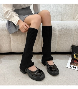 Detail of black knitted leg warmers paired with platform Mary Jane shoes in Y2K style