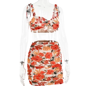Detail of floral two-piece set featuring red cropped top and ruffled mini skirt