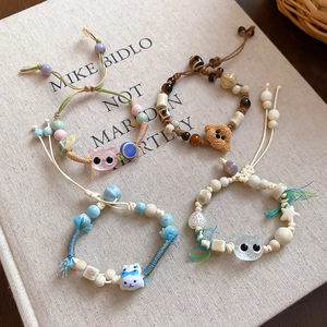 Detailed view of four handmade ceramic and beaded bracelets on a vintage cloth book cover