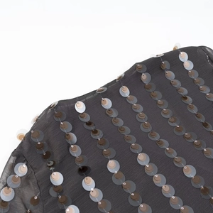 Detailed close-up of colorful sequins on dark grey translucent fabric of the V-neck jumpsuit