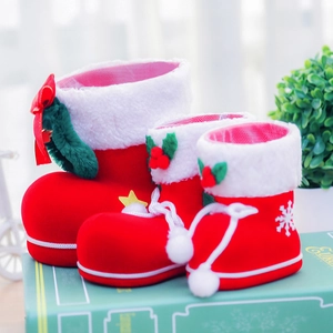 Close-up of three red flocked Christmas candy boots with white faux fur and berry accents