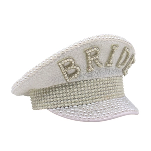 Chapeau de mariée blanc avec paillettes et perles, vue latérale d'une casquette de fête