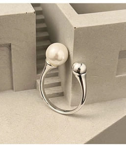 Detail of s925 silver open ring featuring a round white pearl and a polished metal ball