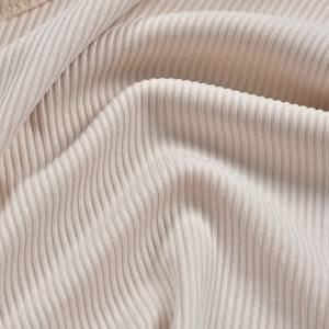 Vue macro d'un tissu en maille côtelée beige montrant des détails de texture douce
