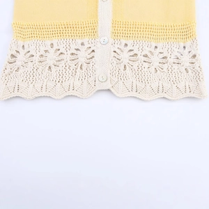 Women's yellow and cream knit cardigan with crochet floral patterns and pearl buttons