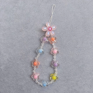 Macro detail of colorful acrylic flower beads on a sweet style mobile phone charm strap