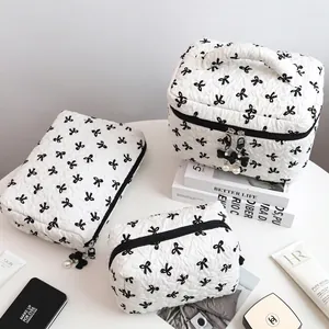 Three-piece quilted white makeup bag set with black bow patterns and pearl charms