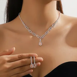 Close-up of peach crystal necklace and water drop earrings set on model neck