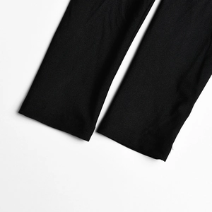 Détail du bas de jambe de la combinaison noire avec tissu lisse et coutures précises