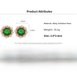 Detail view of retro flower earrings with green stones and imitation pearls
