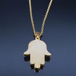 Golden Hamsa Hand evil eye necklace with brushed metal finish on dark reflective background