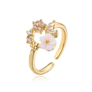 Macro shot of 18K gold open ring with pink zircons and detailed white flower petals