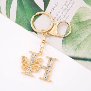 Detailed close-up of gold butterfly letter H keychain with sparkling rhinestones
