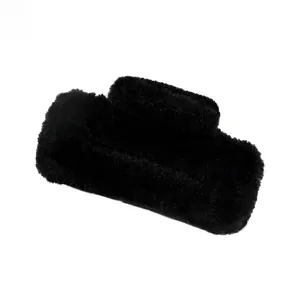 Macro detail of plush black faux fur texture on a large rectangular hair claw clip