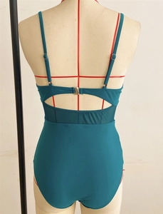 Detail of backless one-piece swimsuit with mesh panels and adjustable straps in teal