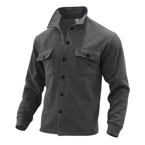 Detail of dark grey shacket featuring flap chest pockets and metallic snap buttons