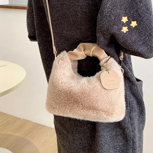 Plush faux fur crossbody handbag in beige with ruched leather handle and gold chain tag