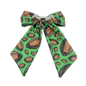 Detail of green football pattern fabric bow hair clip with metal spring fastener