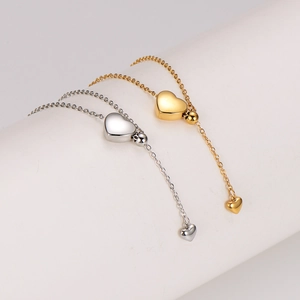 Minimalist heart pendant tassel necklaces in gold and silver finish on white display