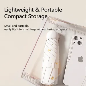 Mini cream sun umbrella with gold hearts shown next to a smartphone for size comparison