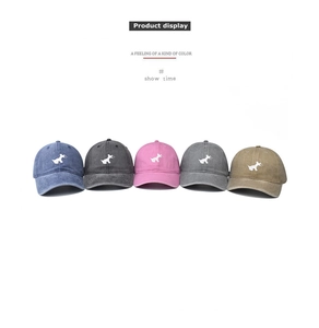 Detail of washed cotton baseball caps with dog embroidery in five assorted colors